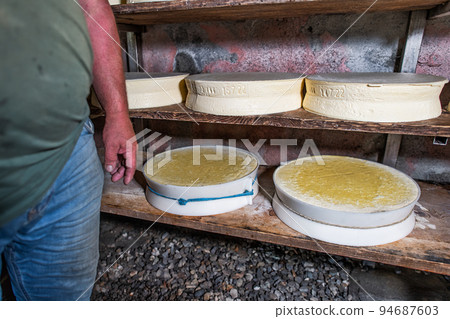 Interior of an alpine hut with typical forms of local cheese Interior of an alpine hut with typical forms of local cheese 94687603