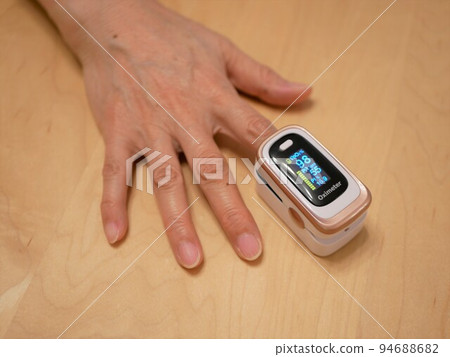 Elderly woman's hand using a pulse oximeter 94688682