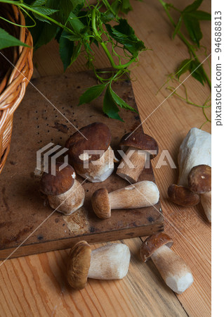 Several porcini mushrooms on wooden background at autumn season.. 94688813