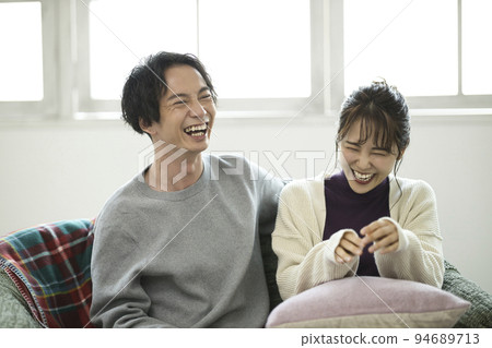 放鬆在沙發的一對年輕夫婦 放鬆在沙發的一對年輕夫婦 94689713