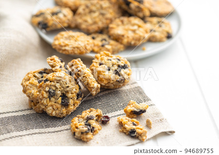 Wholegrain oat cookies. Cookies with oatmeal and raisins on white table. Wholegrain oat cookies. Cookies with oatmeal and raisins on white table. 94689755