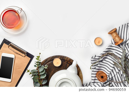 Still life with tea cup and the contents of a workspace composed. Different objects on white table. Flat lay Still life with tea cup and the contents of a workspace composed. Different objects on white table. Flat lay 94690059