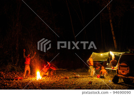 Two people are having fun playing ghosts at their forest camping in the night 94690090