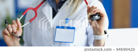 Female medical worker in white uniform posing with stethoscope on neck 94690420