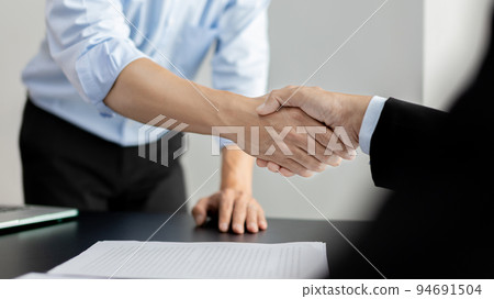 Businessman shaking hands with a lawyer or judge After signing the contract and the agreement is complete, Approval of an agreement between business and law, End of the legal case. Businessman shaking hands with a lawyer or judge After signing the contract and the agreement is complete, Approval of an agreement between business and law, End of the legal case. 94691504