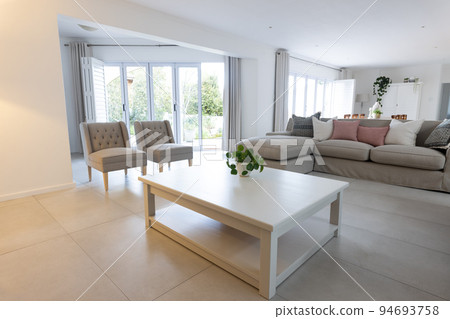 The interior of a beautiful large modern living room with large windows The interior of a beautiful large modern living room with large windows 94693758