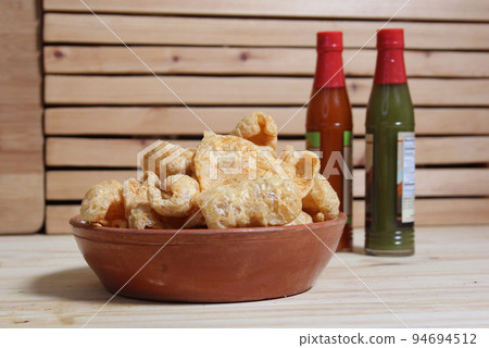 Fried Pork Skins With Hot Sauce in Rustic Kitchen Fried Pork Skins With Hot Sauce in Rustic Kitchen 94694512