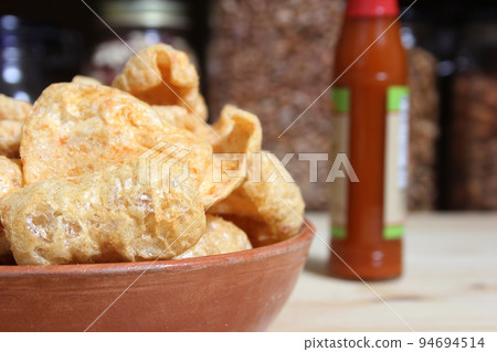Fried Pork Skins With Hot Sauce in Rustic Kitchen Fried Pork Skins With Hot Sauce in Rustic Kitchen 94694514