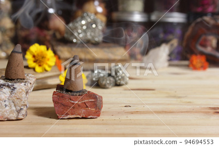 Incense Cones and Chakra Stones With Flowers in Background Shallow DOF Incense Cones and Chakra Stones With Flowers in Background Shallow DOF 94694553