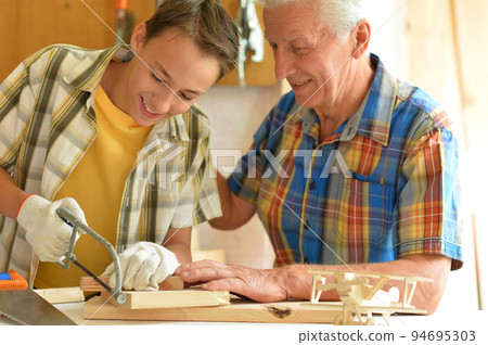 Grandfather and his grandson made an airplane model Grandfather and his grandson made an airplane model 94695303