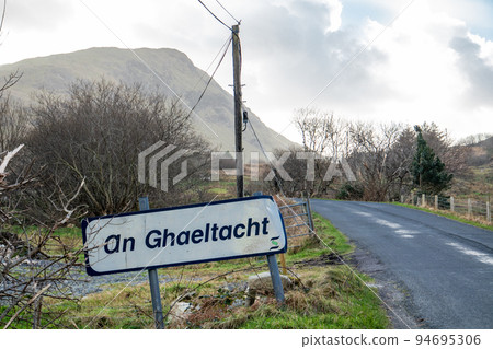 An Ghaeltacht road sign explaining that here starts an area where the irish language is spoken - Translation: Irish 94695306