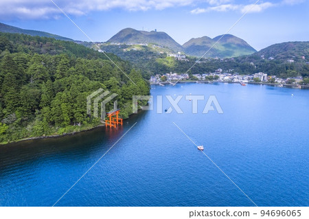 Drone aerial view of the torii gate of peace over Lake Ashi in summer, over Hakone Shrine in clear weather Drone aerial view of the torii gate of peace over Lake Ashi in summer, over Hakone Shrine in clear weather 94696065