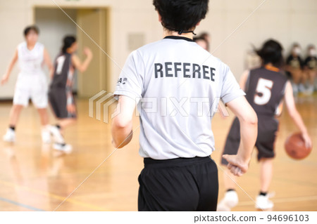Referee runs during basketball game 94696103