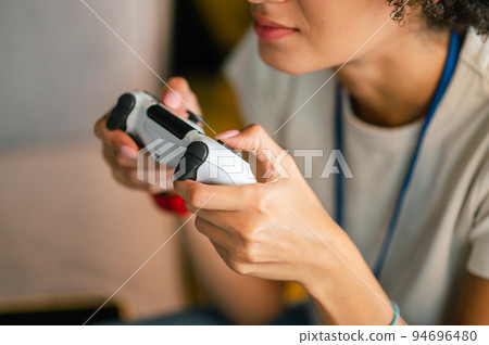 Young girl in white tshirt playong on playstation 94696480