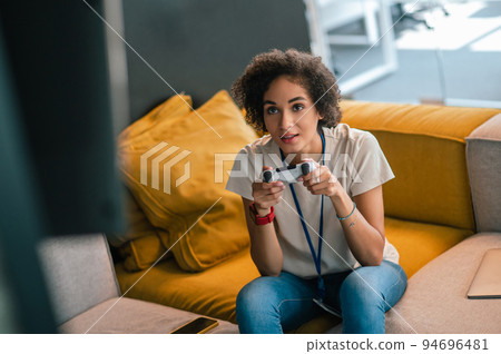 Young girl in white tshirt playong on playstation 94696481