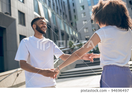 Happy cute young couple dancing in the street Happy cute young couple dancing in the street 94696497