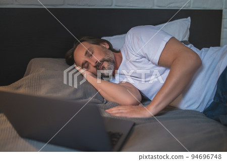 Man napping while watching movie online Man napping while watching movie online 94696748