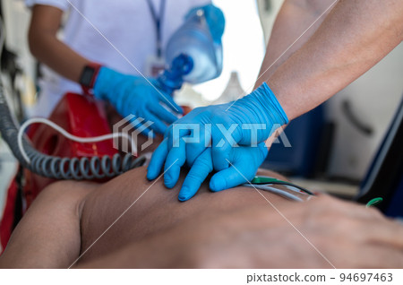 Paramedical staff performing the heart massage and oxygenation procedure 94697463