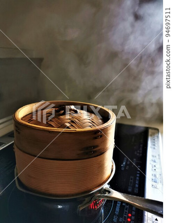 Steaming basket steaming full of steam in the kitchen of the house Steaming basket steaming full of steam in the kitchen of the house 94697511