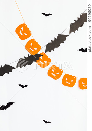 Trick or Treat concept. Holiday composition with halloween garland decorations pumpkins and bats isolated on white background. Preparation for Halloween party. Autumn fall happy Halloween. 94698020