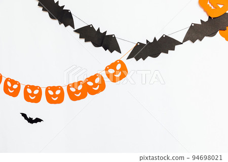 Trick or Treat concept. Holiday composition with halloween garland decorations pumpkins and bats isolated on white background. Preparation for Halloween party. Autumn fall happy Halloween. 94698021