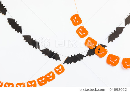 Trick or Treat concept. Holiday composition with halloween garland decorations pumpkins and bats isolated on white background. Preparation for Halloween party. Autumn fall happy Halloween. Trick or Treat concept. Holiday composition with halloween garland decorations pumpkins and bats isolated on white background. Preparation for Halloween party. Autumn fall happy Halloween. 94698022