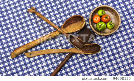 Rustic wooden spoons amd tomatoes on the table. 94698133