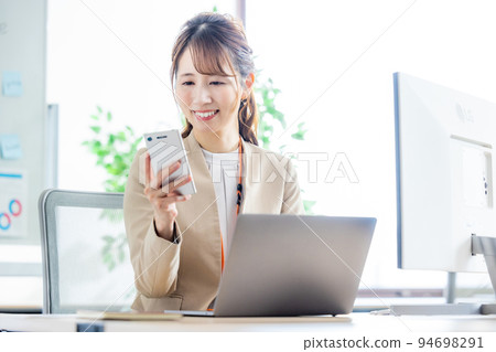 Business woman using a smartphone in the office 94698291