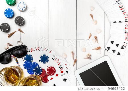 Gambling. Poker chips, cards and the dice nearby tablet on wooden table. Top view. Copyspace. Poker Gambling. Poker chips, cards and the dice nearby tablet on wooden table. Top view. Copyspace. Poker 94698422
