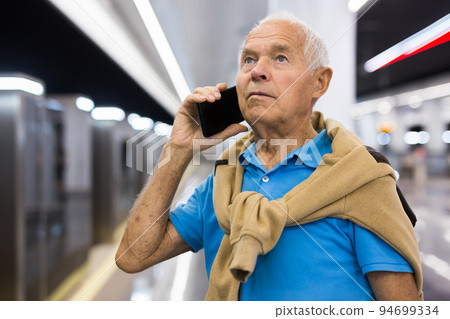Senior man with phone in metro station 94699334