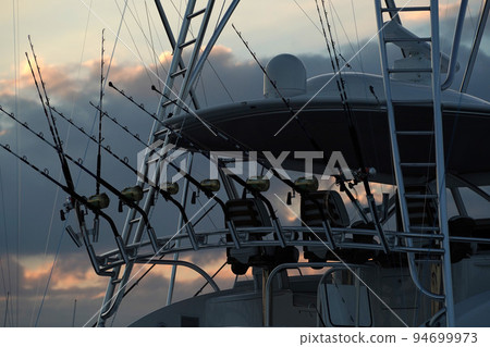 detail of many fishing rod on a boat at sunset 94699973
