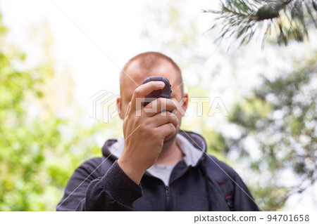 A man with a navigator in the forest. Location orientation. GPS signal reception. A man with a navigator in the forest. Location orientation. GPS signal reception. 94701658