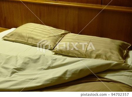 two pillow and  blanket opened for one people on pair bed in night 94702357