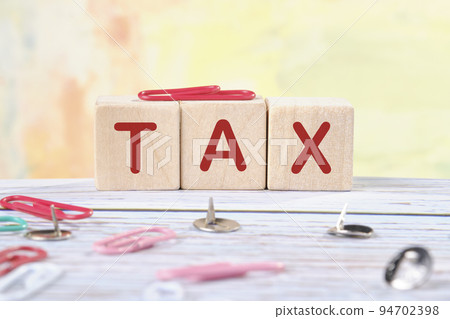 Tax text on wooden cubes on a colored background, Tax Concept 94702398