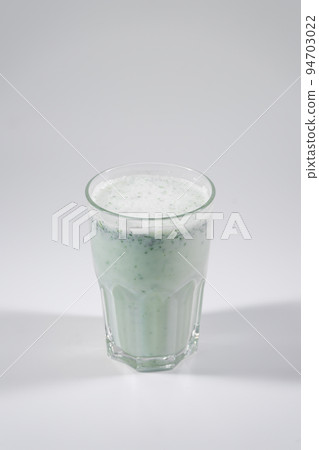 glass with fresh matsoni with greens and cucumber isolated on white background 94703022