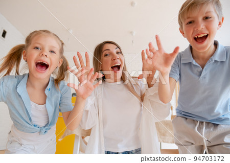 Happy mother with children, small son and daughter running towards 94703172