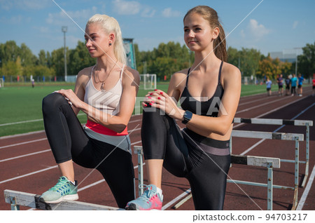 Two athlete young woman runnner at the stadium 94703217