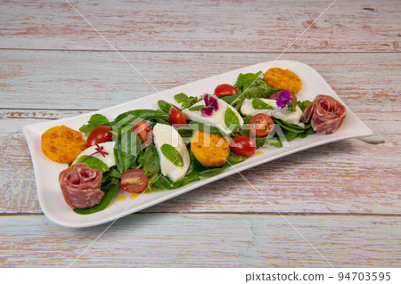 Arugula and spinach salad recipe with mozarella sausage, prickly pear vinaigrette 94703595
