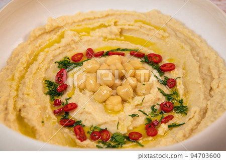 Homemade hummus with tahini plate with olive oil and paprika and pita isolated on brown background 94703600