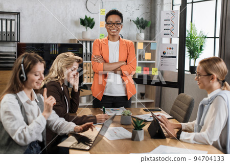 Young african woman standing at boardroom standing at boardroom with crossed arms Young african woman standing at boardroom standing at boardroom with crossed arms 94704133