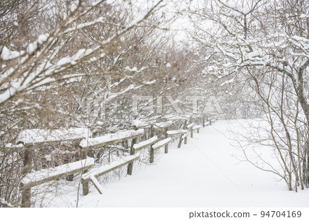 Wooden fence in the snow on winter country background 94704169