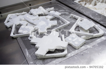 Detail objects printed on powder 3D printer and covered white polyamide powder close-up. Technology Multi Jet Fusion MJF. 3D prototype models created by new additive progressive 3d printing technology Detail objects printed on powder 3D printer and covered white polyamide powder close-up. Technology Multi Jet Fusion MJF. 3D prototype models created by new additive progressive 3d printing technology 94705102
