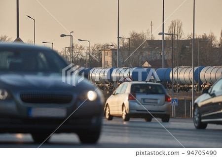 Road and rail transportation, oil freight wagons and cars passing 94705490