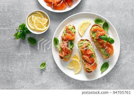 Toasts with salted salmon and avocado guacamole, top view 94705761