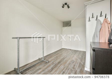 White wardrobe with mirrors located near guitar and cabinet in light room at home White wardrobe with mirrors located near guitar and cabinet in light room at home 94706378