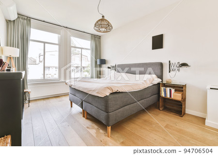 Home interior design of bedroom with bed and wooden wardrobe placed in corner near window in modern apartment Home interior design of bedroom with bed and wooden wardrobe placed in corner near window in modern apartment 94706504