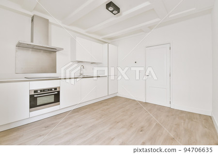 Interior of empty white kitchen with windows and wooden parquet floor Interior of empty white kitchen with windows and wooden parquet floor 94706635