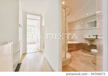 Flush toilet located between sink and shower in small tiled bathroom of contemporary apartment Flush toilet located between sink and shower in small tiled bathroom of contemporary apartment 94706673