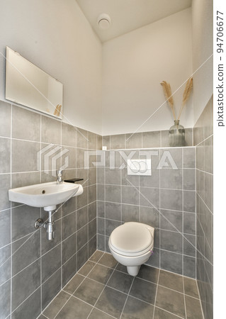 Sink base cabinet and mirror cabinet in white tiled bathroom with wall hung toilet Sink base cabinet and mirror cabinet in white tiled bathroom with wall hung toilet 94706677