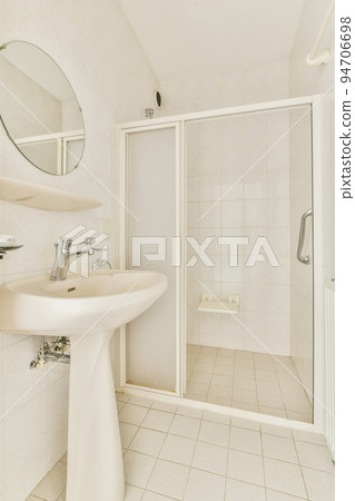 Sink and mirror located near flush toilet Sink and mirror located near flush toilet 94706698
